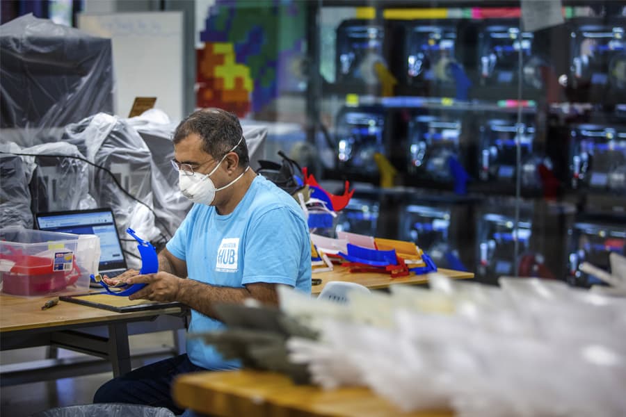 Ebrahim Montazeri finishing 3D printed face shield brackets at the FSU Innovation Hub